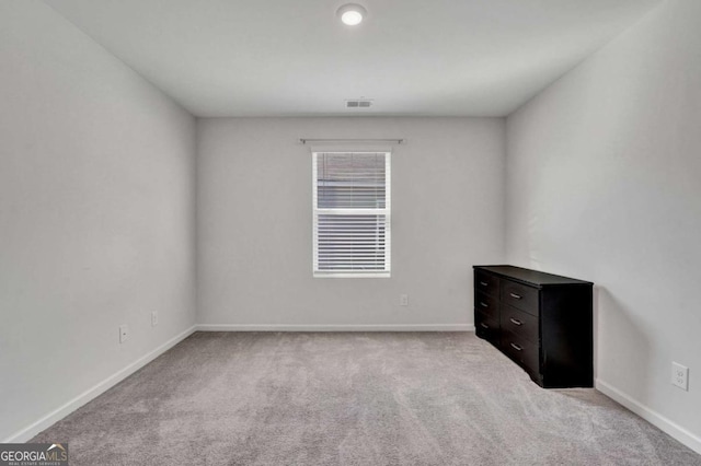 spare room with visible vents, baseboards, and carpet