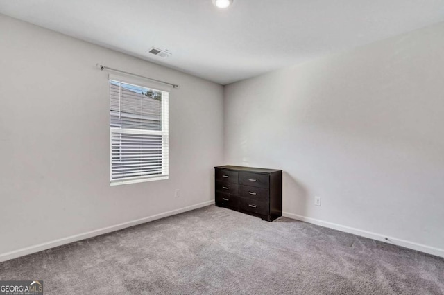 unfurnished room featuring visible vents, baseboards, and carpet