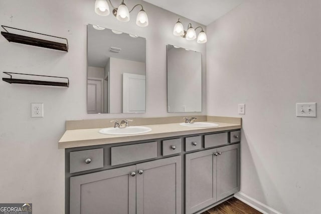 full bathroom featuring double vanity, wood finished floors, baseboards, and a sink