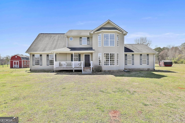 rear view of house featuring an outbuilding, a porch, a yard, crawl space, and a barn