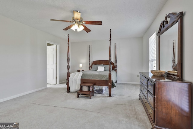 bedroom featuring light colored carpet, a textured ceiling, baseboards, and ceiling fan