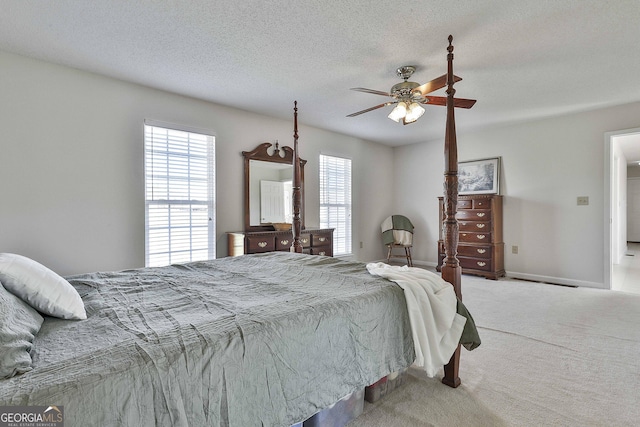 carpeted bedroom with baseboards, a textured ceiling, and a ceiling fan