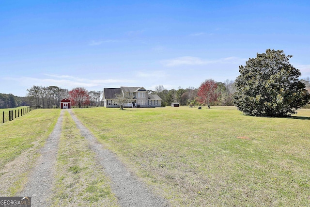 view of yard featuring an outbuilding, fence, and a barn