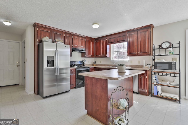 kitchen featuring a center island, under cabinet range hood, stainless steel refrigerator with ice dispenser, black electric range oven, and reddish brown cabinets