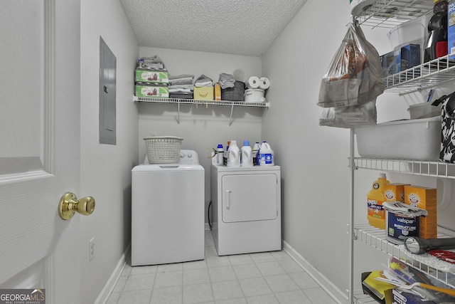 clothes washing area with baseboards, laundry area, electric panel, separate washer and dryer, and a textured ceiling