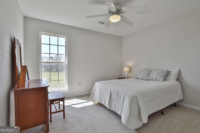 bedroom featuring visible vents, light carpet, baseboards, and ceiling fan