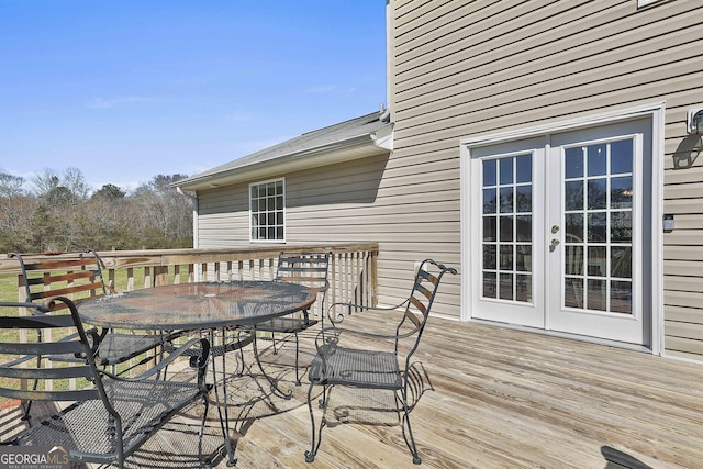 wooden terrace with french doors and outdoor dining space