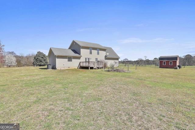 view of yard with an outbuilding, cooling unit, and a wooden deck