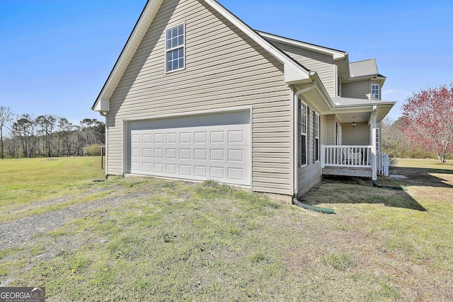 view of home's exterior with a porch, a lawn, a garage, and driveway