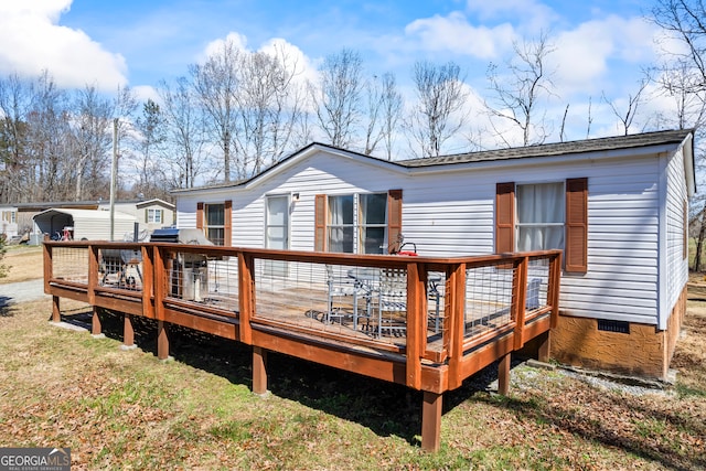 rear view of house with crawl space, a lawn, and a wooden deck