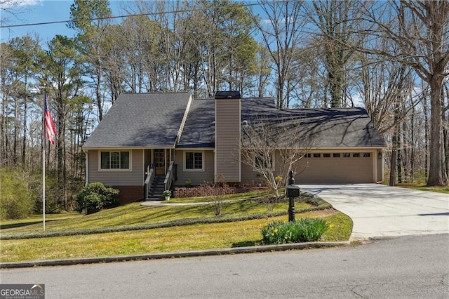 view of front of home with a front lawn, roof with shingles, a chimney, a garage, and driveway