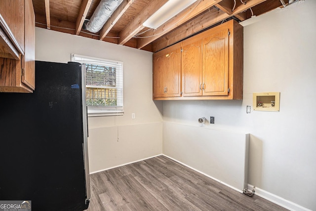 washroom with dark wood-style floors, cabinet space, hookup for a washing machine, and baseboards