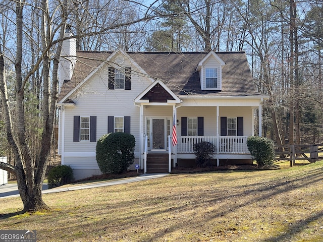 cape cod home with a porch, a shingled roof, and a front yard