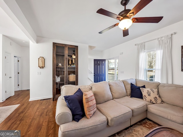 living room featuring baseboards, wood finished floors, visible vents, and ceiling fan