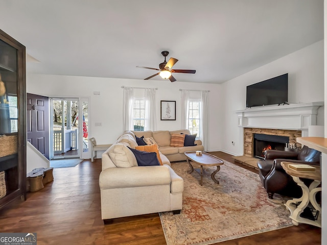 living area with dark wood finished floors, a fireplace, and ceiling fan