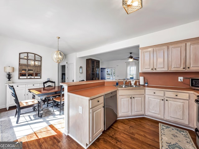 kitchen with dark wood-type flooring, ceiling fan with notable chandelier, a peninsula, stainless steel appliances, and a sink