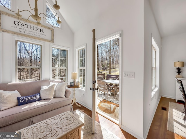 sunroom with a wealth of natural light, visible vents, and vaulted ceiling