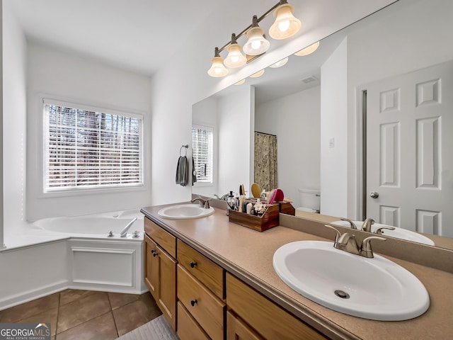 bathroom featuring tile patterned floors, toilet, a garden tub, and a sink