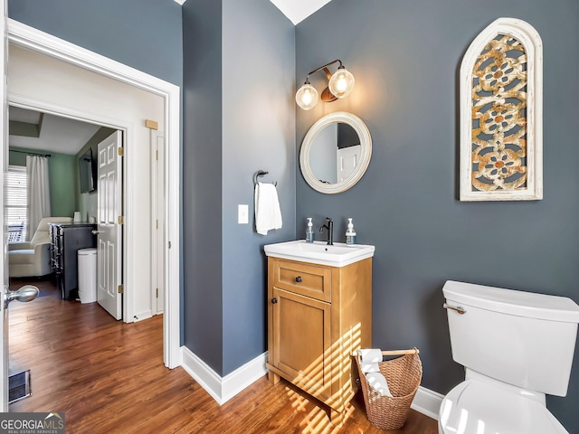 bathroom with visible vents, baseboards, wood finished floors, and vanity