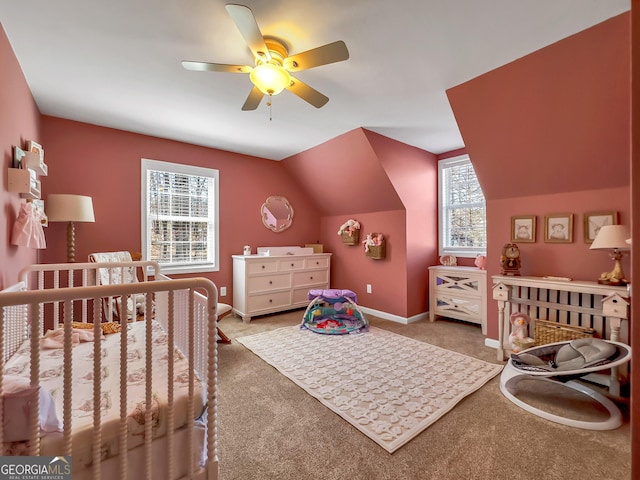 bedroom featuring carpet, baseboards, ceiling fan, vaulted ceiling, and a nursery area