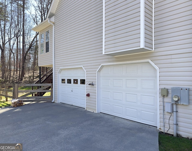 view of side of property featuring aphalt driveway and a garage