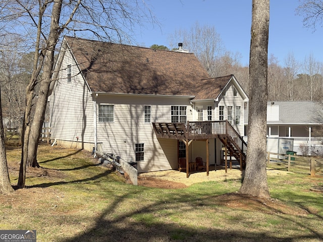 back of house with a wooden deck, a lawn, stairs, and a shingled roof