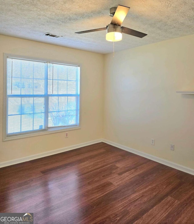 spare room with ceiling fan, baseboards, a textured ceiling, and wood finished floors