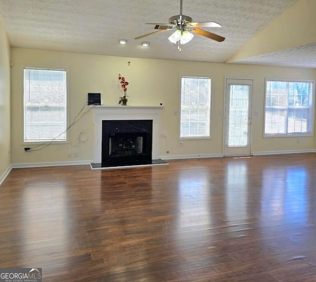 unfurnished living room with a textured ceiling, wood finished floors, lofted ceiling, and a premium fireplace