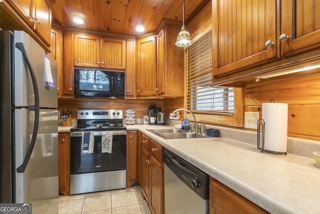 kitchen featuring light tile patterned flooring, stainless steel appliances, light countertops, and a sink