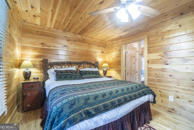 bedroom with wood walls, wooden ceiling, light wood-type flooring, and ceiling fan