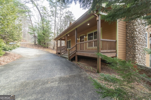 view of home's exterior with covered porch and driveway