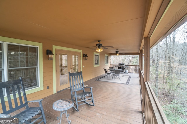 wooden terrace featuring outdoor dining space and a ceiling fan