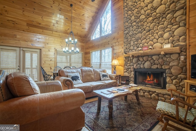 living area featuring wooden walls, wood ceiling, a fireplace, a notable chandelier, and high vaulted ceiling