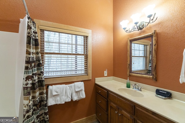 full bathroom featuring vanity and a textured wall