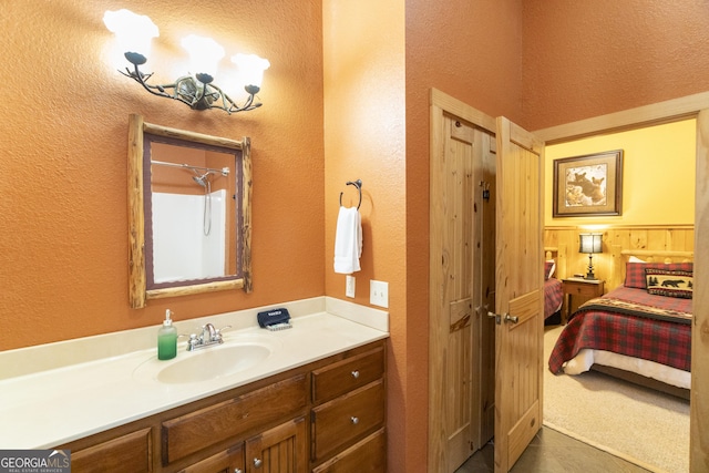 full bath featuring vanity and a textured wall