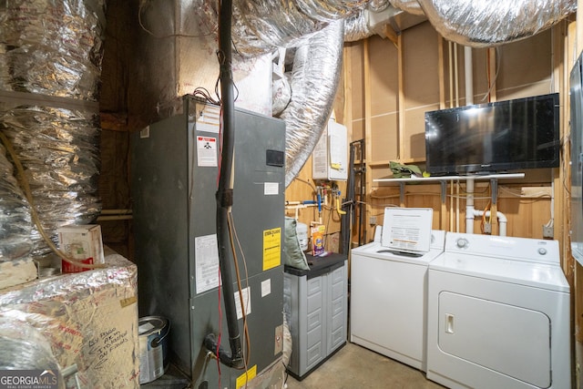 interior space with washer and clothes dryer, laundry area, and heating unit