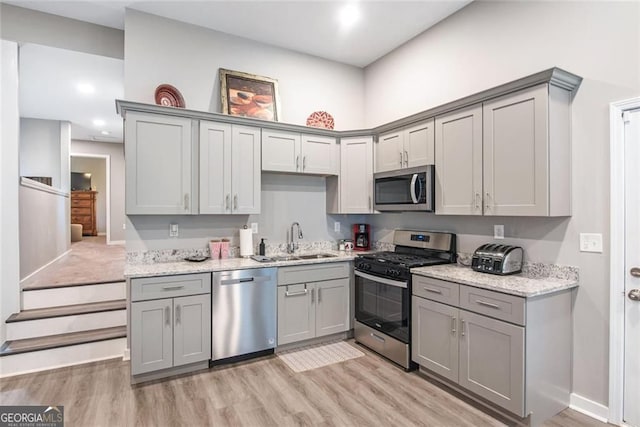 1041 Lawton Ave SW, Atlanta, GA 30310 - kitchen with a sink, light wood-style floors, gray cabinets, and stainless steel appliances