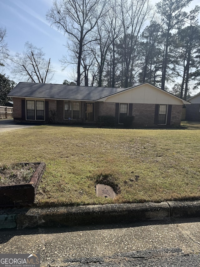 view of front of home with a front yard and brick siding