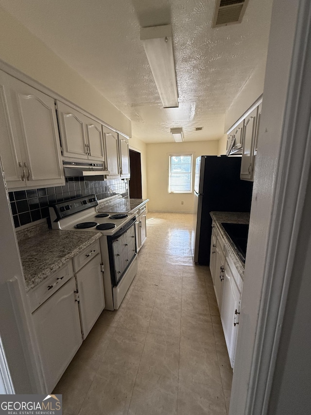 kitchen with visible vents, under cabinet range hood, white cabinetry, backsplash, and white range with electric stovetop