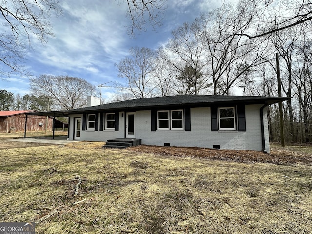 ranch-style house featuring crawl space, a chimney, brick siding, and a carport