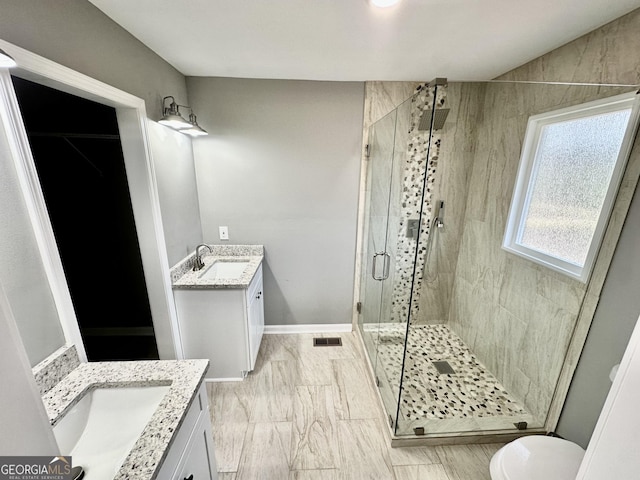 bathroom featuring visible vents, toilet, a stall shower, and vanity