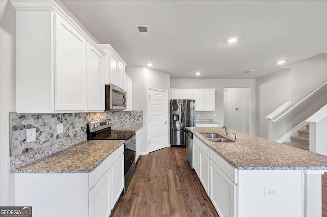 kitchen featuring visible vents, a sink, backsplash, stainless steel appliances, and white cabinets