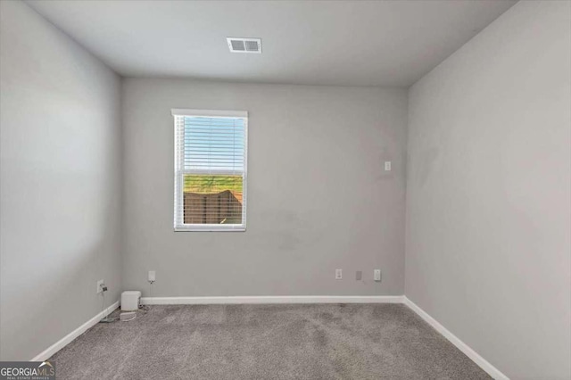 carpeted spare room featuring baseboards and visible vents