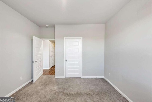 unfurnished bedroom with carpet and baseboards