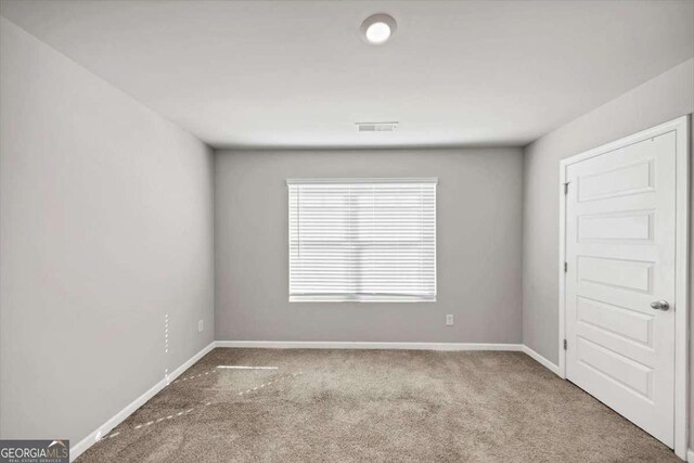 unfurnished room featuring visible vents, baseboards, and carpet