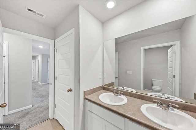 full bathroom featuring double vanity, visible vents, toilet, and a sink