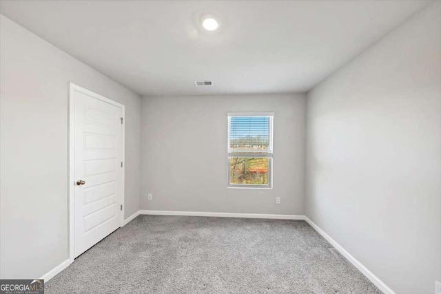 carpeted empty room with visible vents and baseboards