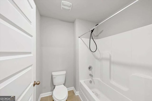 bathroom featuring shower / tub combination, toilet, and baseboards