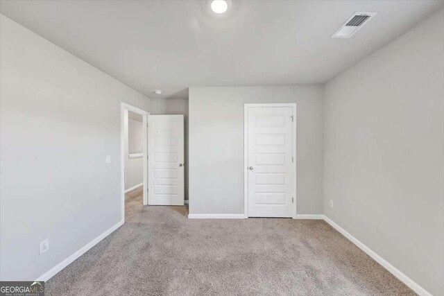 unfurnished bedroom featuring carpet, baseboards, and visible vents