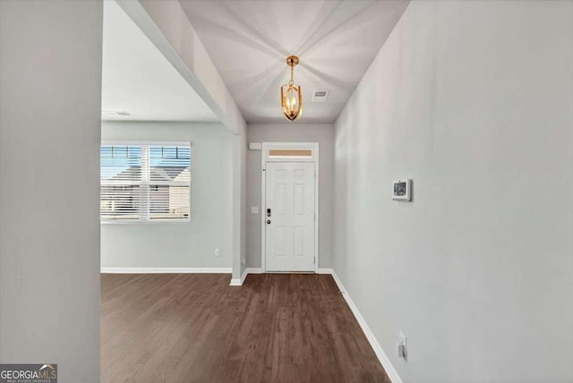 foyer featuring visible vents, baseboards, and wood finished floors